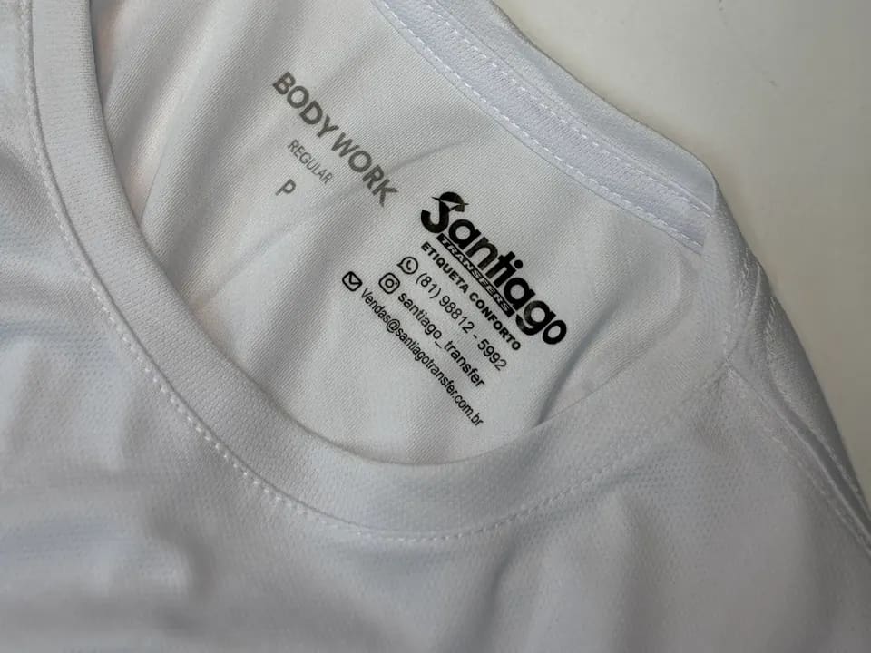 Etiqueta interna impressa na gola de uma camiseta branca, sem costura